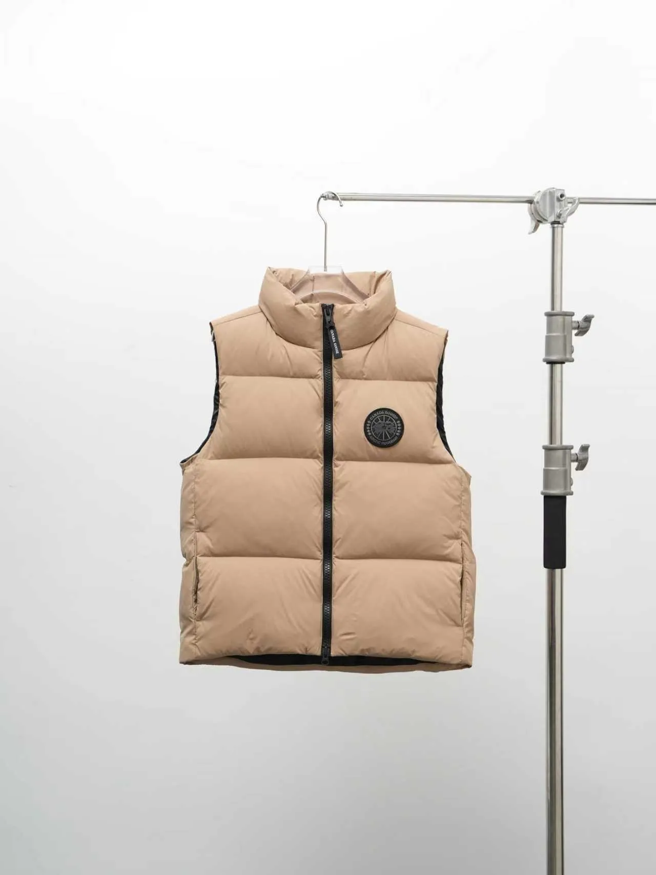 P580 Canada gooes Lawrence Down Vest (high version) With a durable shell and quilted body, the Lawrence Down Vest is a must-have for all seasons. The fabric has a durable soft touch. Longer hem at back for added protection. Reflective double-stripe grip tape at back. The Lawrence features an engineered down-filled collar to block strong winds, a two-way front zip and a longer rear hem. Color: black with red label, black with black label, desert color, ocean blue Size: XS -2XL